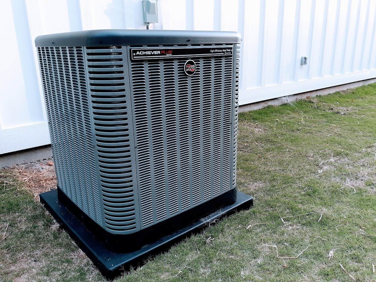 HVAC technician diagnosing an outdoor AC condenser in Phenix City, AL